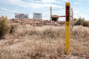 image of oil and gas development and signs in Greater Chaco